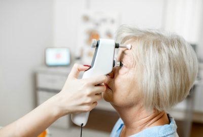 Measuring the eye pressure to a senior woman